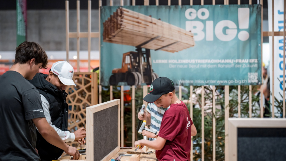 Kinder und Jugendliche probieren an einem Stand an der OBA Holzwerkzeuge aus.