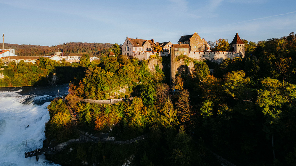 Herbstlandschaft am Wasser mit farbigen Wald.