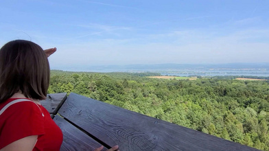 Frau geniesst die Weitsicht vom Napoleonturm bis über den Bodensee nach Deutschland. 