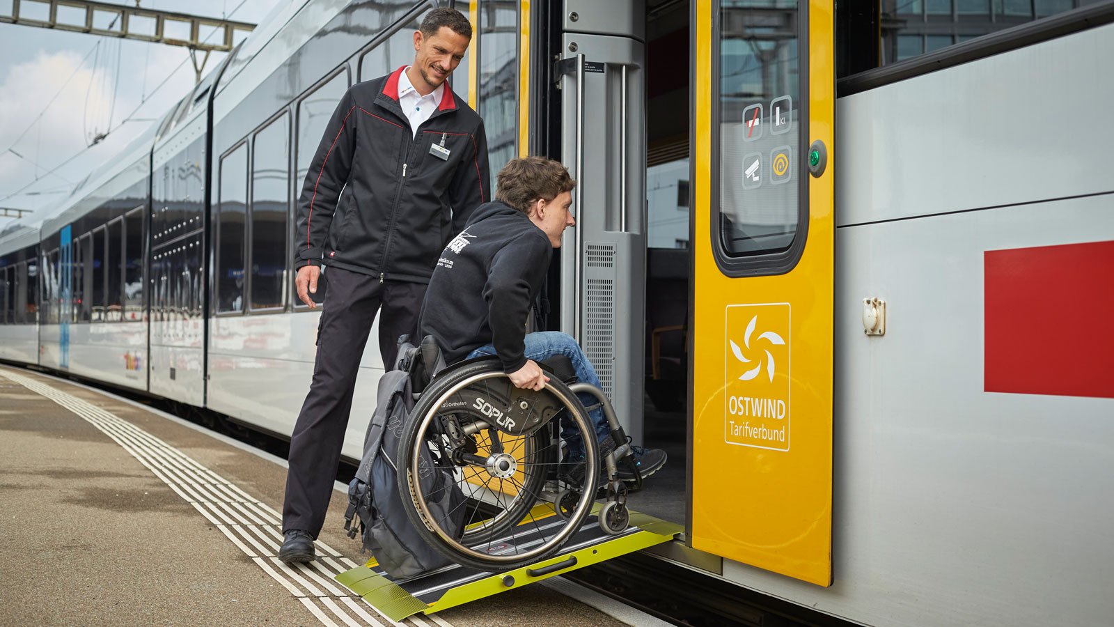 Ein Rollstuhlfahrer fährt über die Rampe in den stehenden Zug