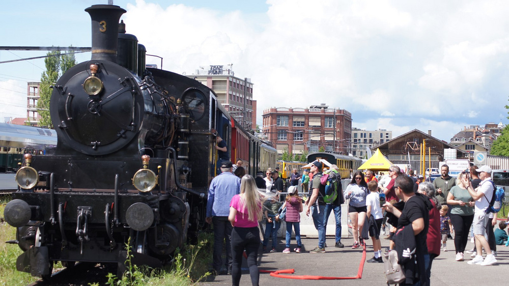 Dampflokomotive und staunende Leute davor.