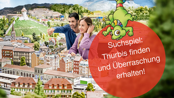 Ein paar steht vor einer Miniaturwelt und bestaunt die Landschaft.
